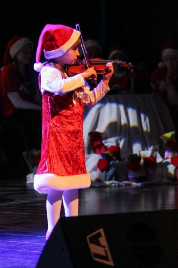 Grająca na skrzypcach Magdalena w mikołajkowym stroju