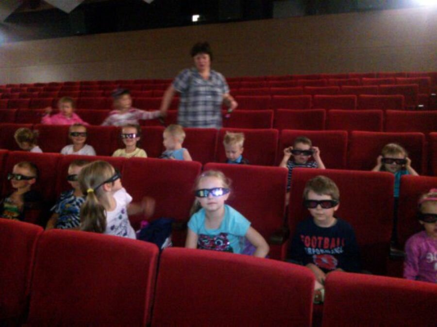 Dzieci siedzą w kinie i czekają na film