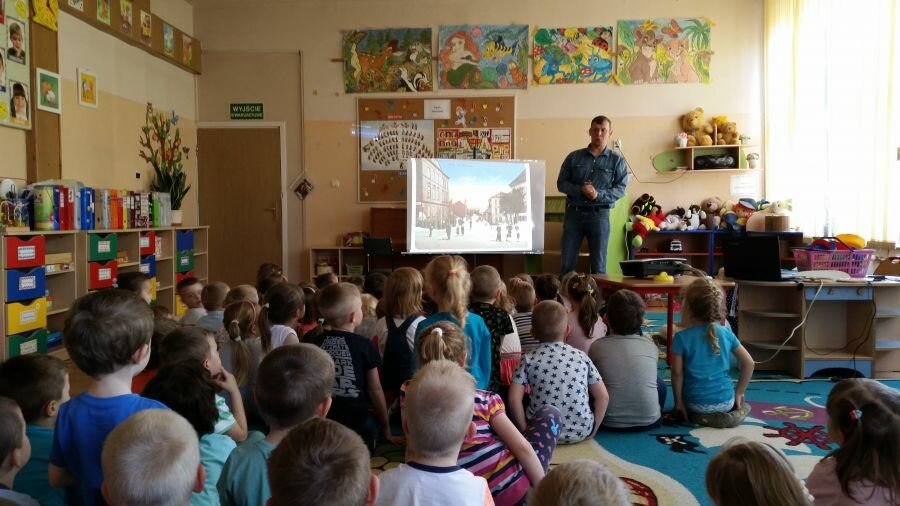 Dzieci oglądają prezentację multimedialną i z uwagą słuchają pana Dworeckiego.