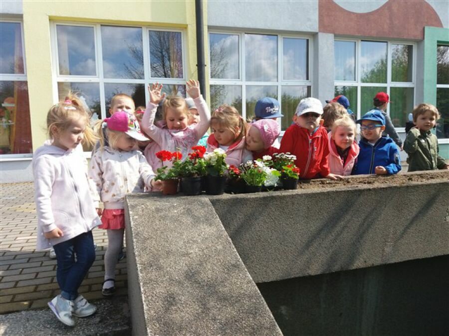 Dzieci przymierzają się do sadzenia kwiatów