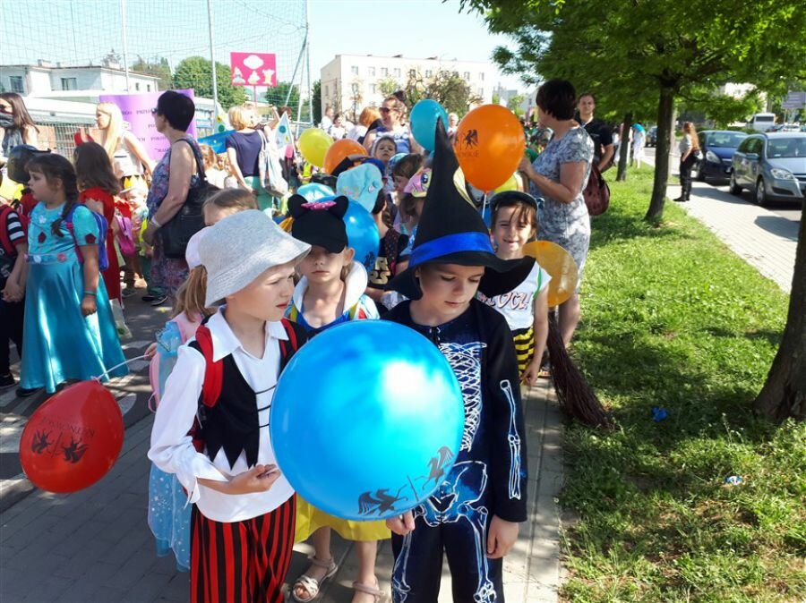 Dzieci przygotowują się do przemarszu ulicami miasta.